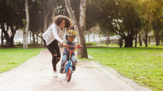 Mother helping child ride a bike